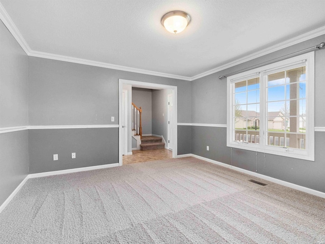 empty room with baseboards, ornamental molding, stairs, and visible vents
