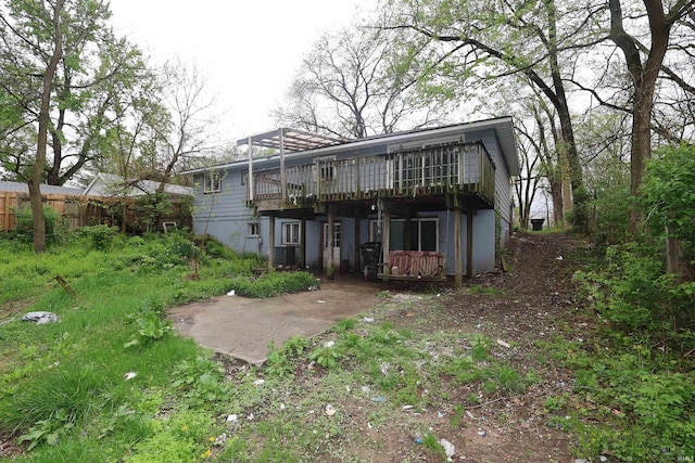 rear view of house with a deck and fence