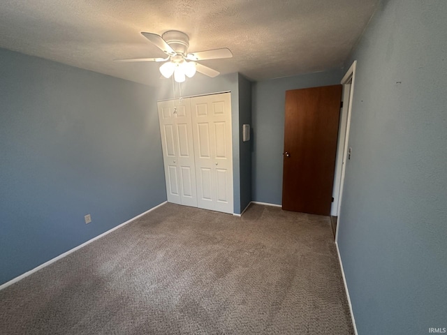 unfurnished bedroom with a ceiling fan, a textured ceiling, carpet floors, baseboards, and a closet
