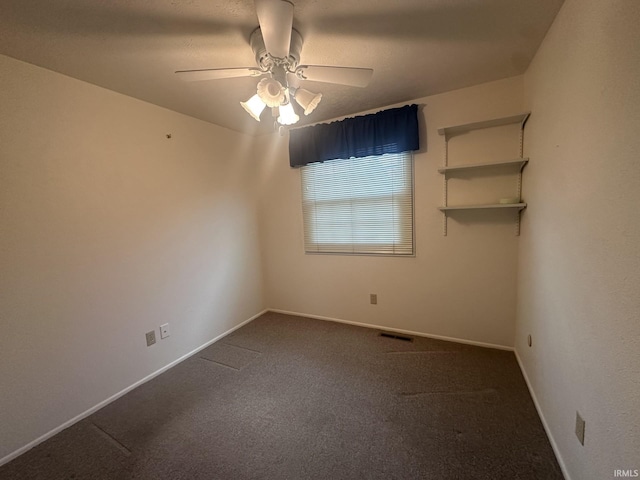 empty room with baseboards, a ceiling fan, dark colored carpet, and visible vents