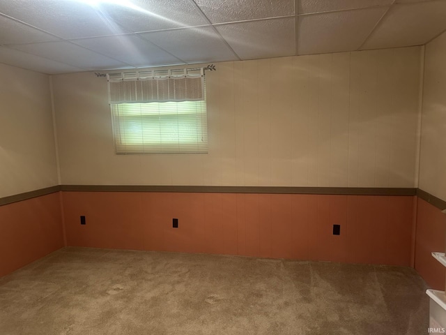 carpeted spare room with wooden walls