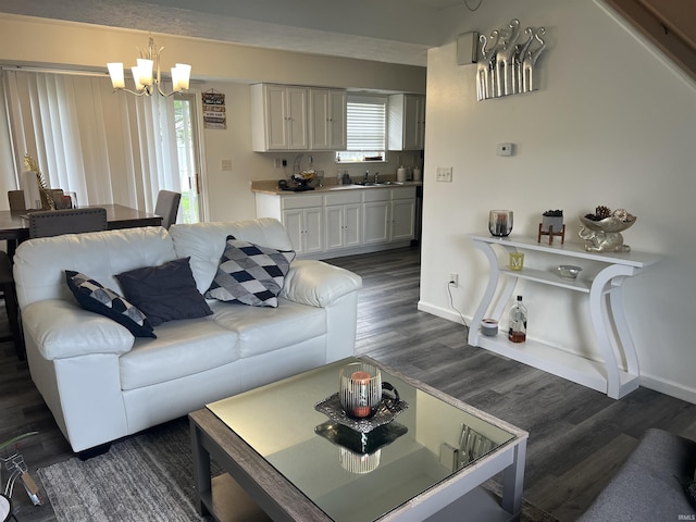 living room with baseboards, a chandelier, and dark wood-type flooring
