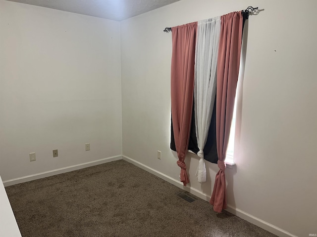spare room with visible vents, carpet flooring, and baseboards