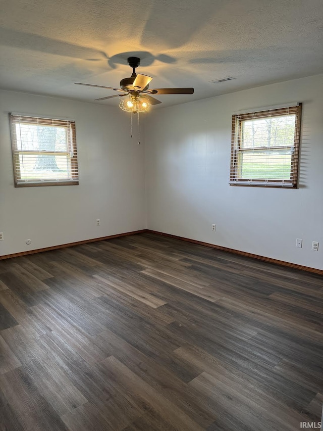 spare room with dark wood finished floors and a wealth of natural light