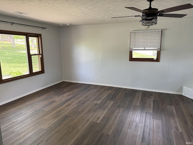 unfurnished room featuring visible vents, wood finished floors, baseboards, a textured ceiling, and a ceiling fan