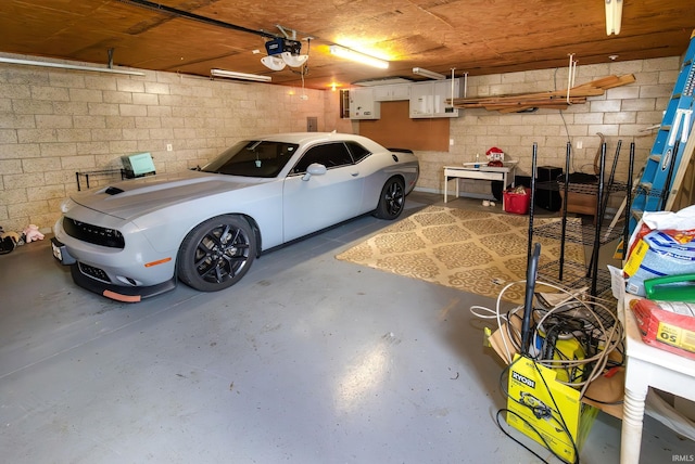 garage with concrete block wall and a garage door opener