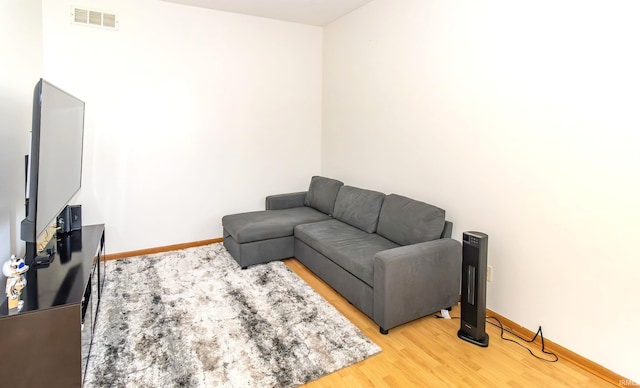 living area featuring baseboards, visible vents, and light wood-style flooring
