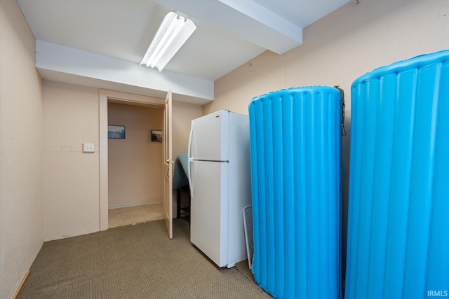 interior space featuring freestanding refrigerator and light carpet