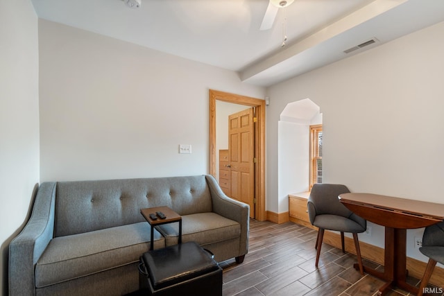 living area with visible vents, baseboards, ceiling fan, and wood finish floors