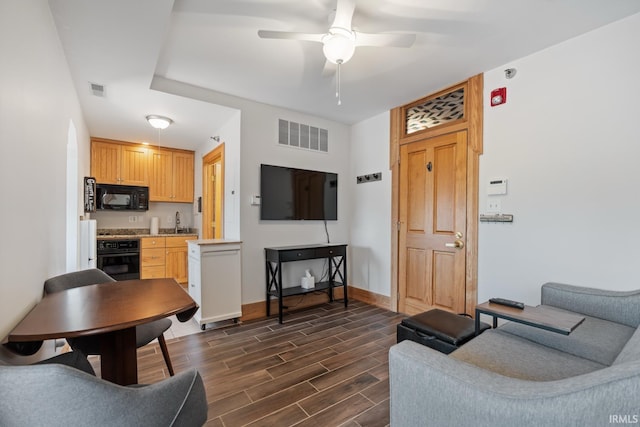 living room featuring a ceiling fan, baseboards, dark wood finished floors, and visible vents