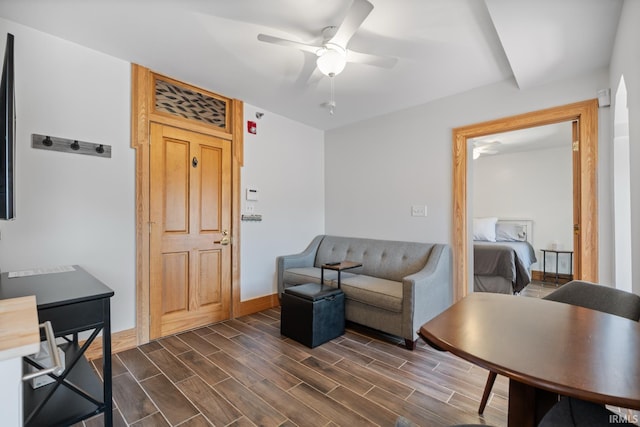 living room with baseboards, dark wood-style flooring, and ceiling fan