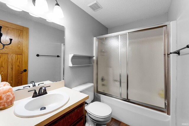 5155 E 200 N, Columbia City, IN 46725 - full bath featuring visible vents, vanity, toilet, bath / shower combo with glass door, and a textured ceiling