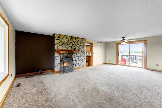 5155 E 200 N, Columbia City, IN 46725 - unfurnished living room featuring ceiling fan, carpet, a stone fireplace, and visible vents