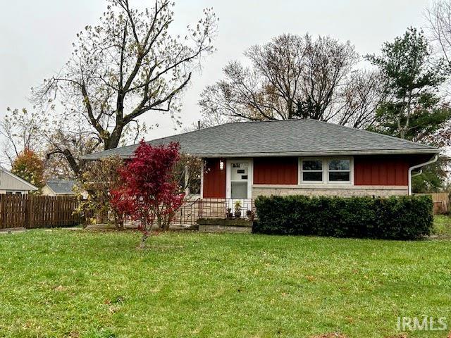 view of front of house with a front lawn and fence