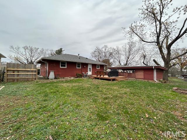 back of house featuring a lawn, fence, and a deck