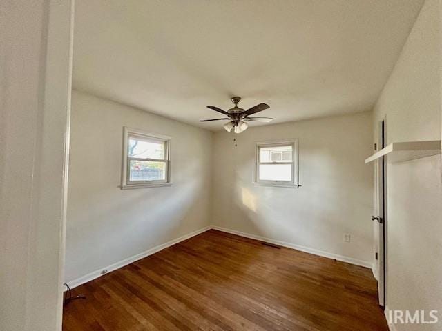 empty room with baseboards, ceiling fan, and wood finished floors
