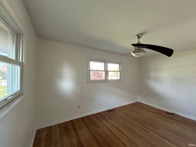 unfurnished room with baseboards, a ceiling fan, wood finished floors, and visible vents