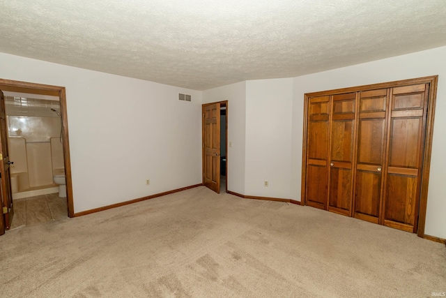 unfurnished bedroom with baseboards, light colored carpet, and visible vents