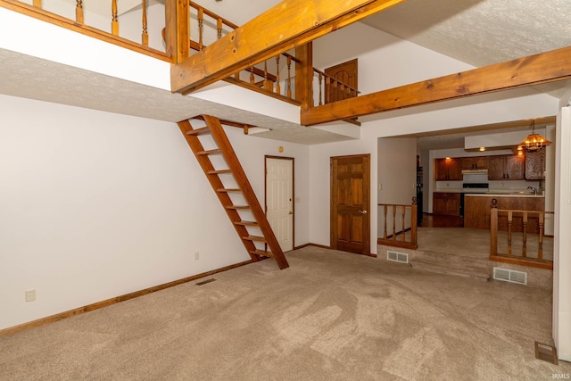 unfurnished living room featuring stairway, baseboards, light carpet, and visible vents