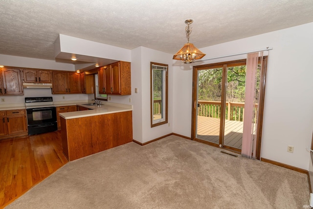 kitchen with baseboards, light countertops, under cabinet range hood, black range with electric stovetop, and a sink