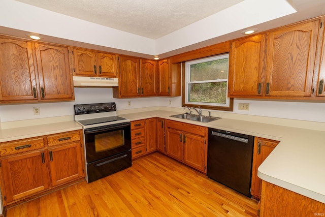 kitchen with range with electric stovetop, black dishwasher, under cabinet range hood, a sink, and light wood-style flooring