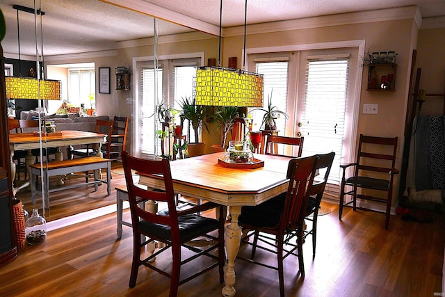 dining area with crown molding, dark wood-style floors, and a textured ceiling