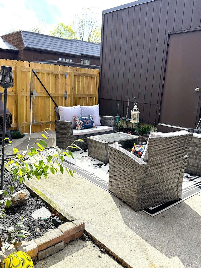 view of patio with an outdoor hangout area, fence, and a gate