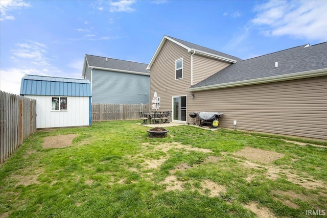 359 Limestone Ct, Lafayette, IN 47909 - back of house featuring a fenced backyard, a shed, a lawn, an outdoor fire pit, and an outbuilding