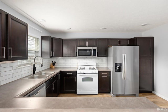 359 Limestone Ct, Lafayette, IN 47909 - kitchen with dark brown cabinetry, a sink, light wood-style floors, stainless steel appliances, and backsplash