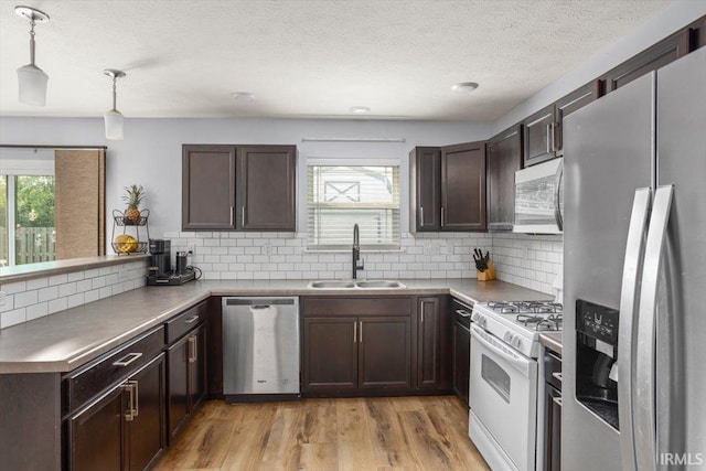359 Limestone Ct, Lafayette, IN 47909 - kitchen with dark brown cabinetry, backsplash, a sink, a peninsula, and stainless steel appliances