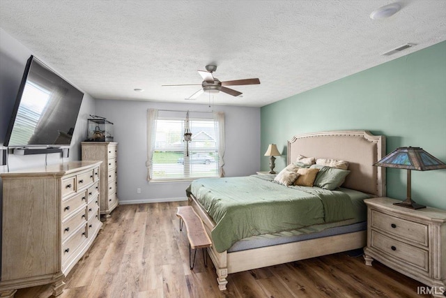 359 Limestone Ct, Lafayette, IN 47909 - bedroom featuring light wood-style floors, a textured ceiling, a ceiling fan, baseboards, and visible vents