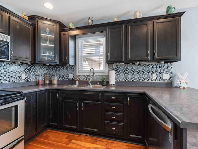 5326 Dennison Dr, Fort Wayne, IN 46835 - kitchen with dark countertops, a sink, stainless steel appliances, light wood-type flooring, and backsplash