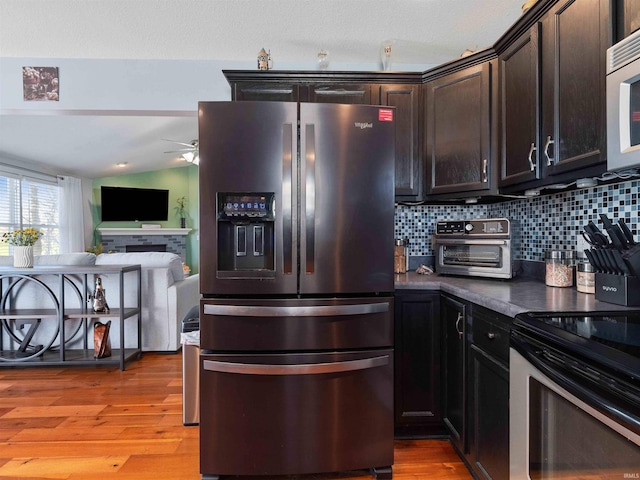 5326 Dennison Dr, Fort Wayne, IN 46835 - kitchen featuring dark brown cabinets, appliances with stainless steel finishes, light wood-style flooring, a ceiling fan, and tasteful backsplash