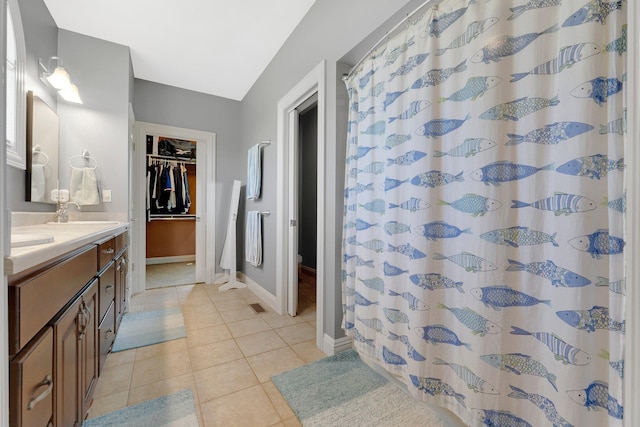 full bathroom featuring a sink, double vanity, tile patterned floors, baseboards, and visible vents