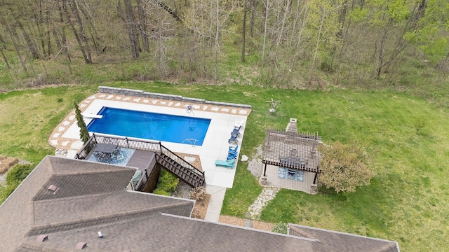 view of pool with a yard, a diving board, a view of trees, and a fenced in pool