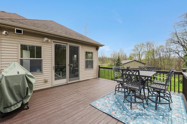wooden terrace featuring outdoor dining area and a grill