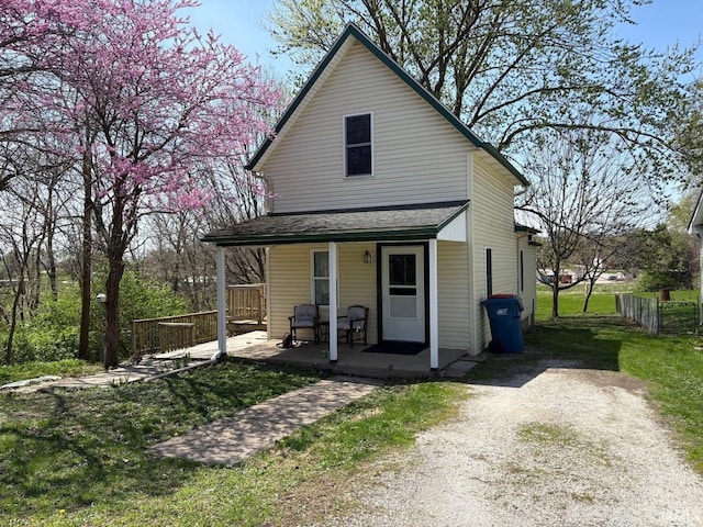 view of front facade featuring fence and covered porch