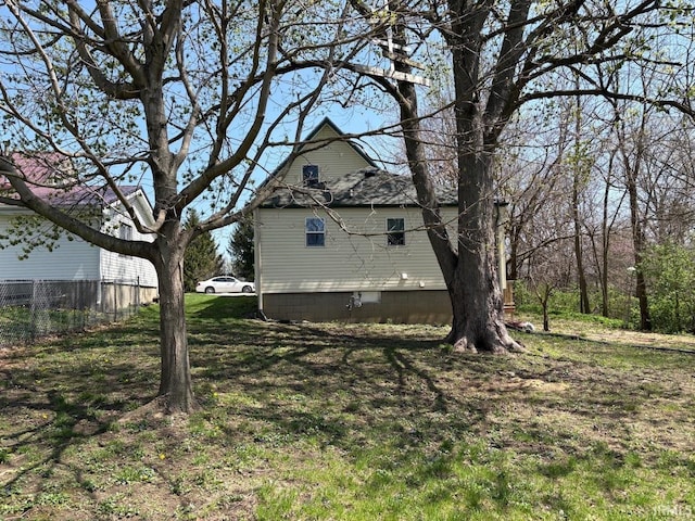 view of property exterior featuring a lawn and fence