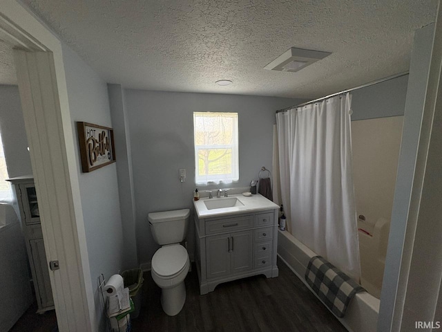 full bathroom featuring a textured ceiling, wood finished floors, vanity, toilet, and shower / bath combo with shower curtain
