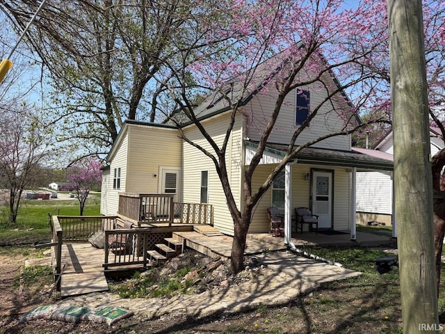 back of house with a porch and a wooden deck