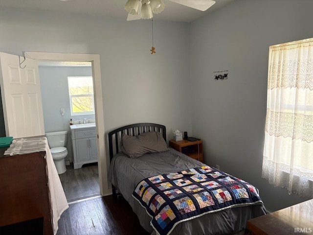 bedroom featuring dark wood-type flooring, a sink, and ensuite bath
