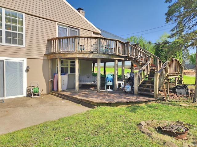 rear view of house featuring stairs, a lawn, and a deck