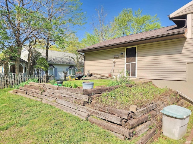 rear view of house featuring a lawn and a vegetable garden