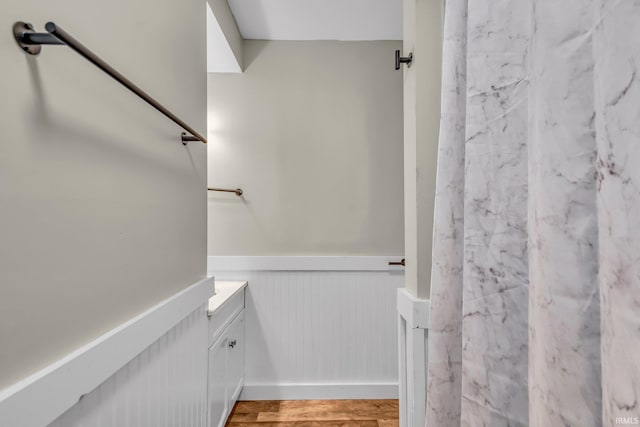 bathroom with vanity, wainscoting, and wood finished floors