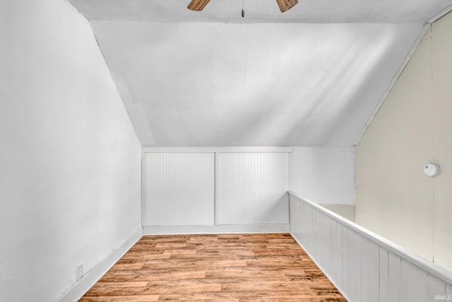 additional living space featuring ceiling fan, vaulted ceiling, and light wood-style flooring