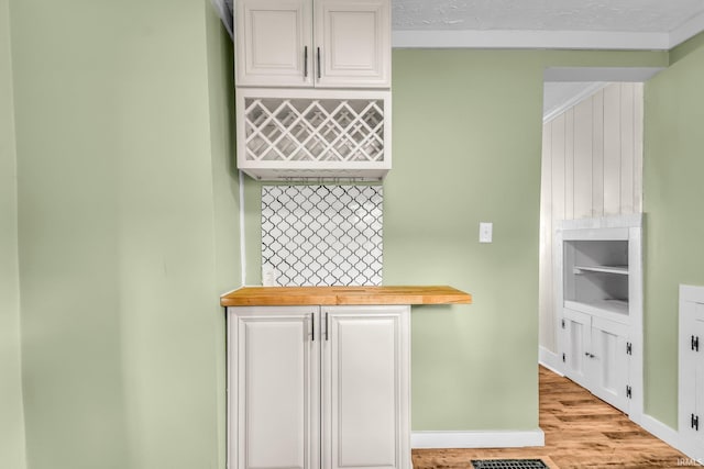interior space featuring baseboards, a dry bar, and wood finished floors