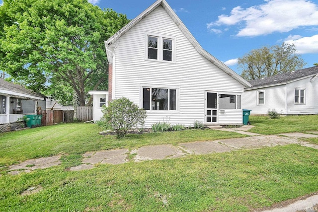 back of house featuring a lawn and fence