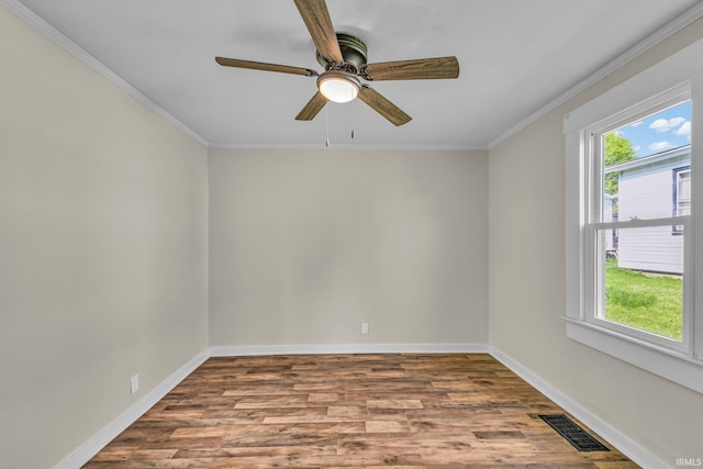 unfurnished room with a ceiling fan, baseboards, wood finished floors, visible vents, and ornamental molding