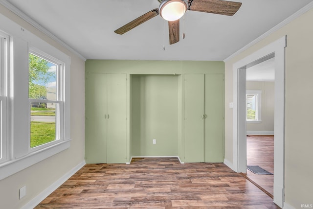 unfurnished bedroom featuring a closet, wood finished floors, and multiple windows