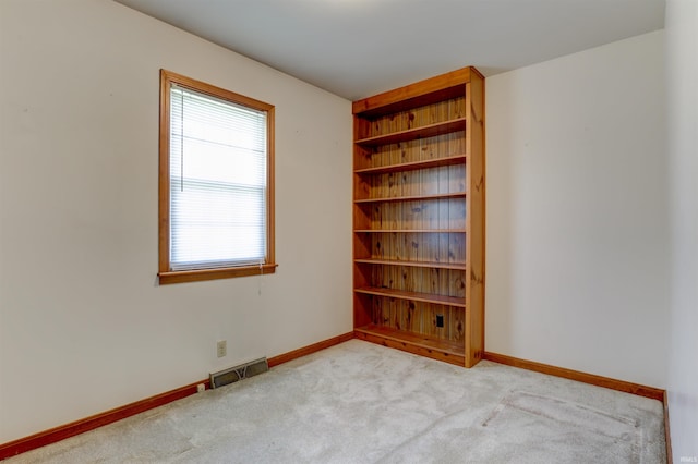 carpeted spare room with baseboards and visible vents